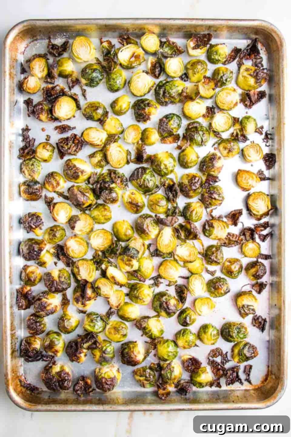 Roasted brussels sprouts on a baking sheet, golden brown with crispy edges.