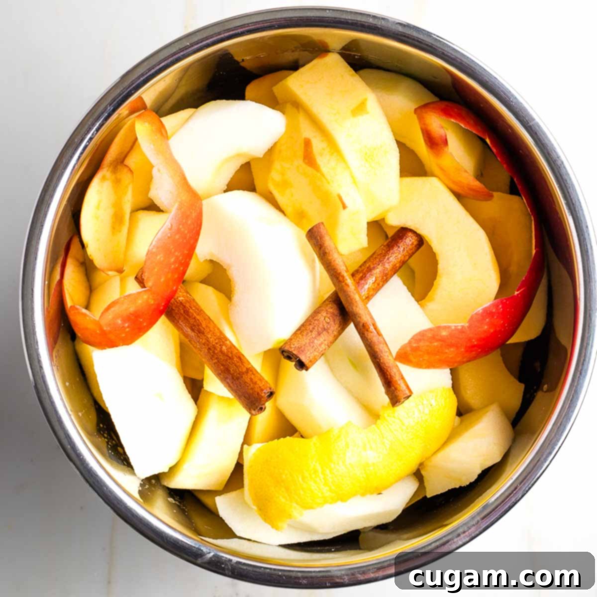 Homemade Sugar-Free Applesauce 6 Apples, lemon peel, and cinnamon sticks in an Instant Pot.