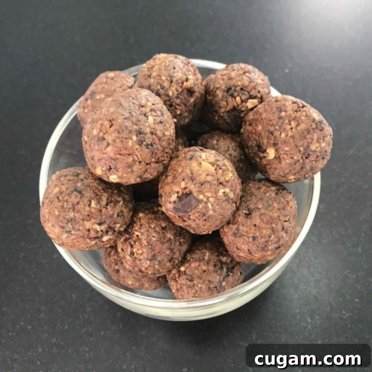 Close-up of a small dish filled with round, brown energy balls, showing the textured surface from oats and nuts.