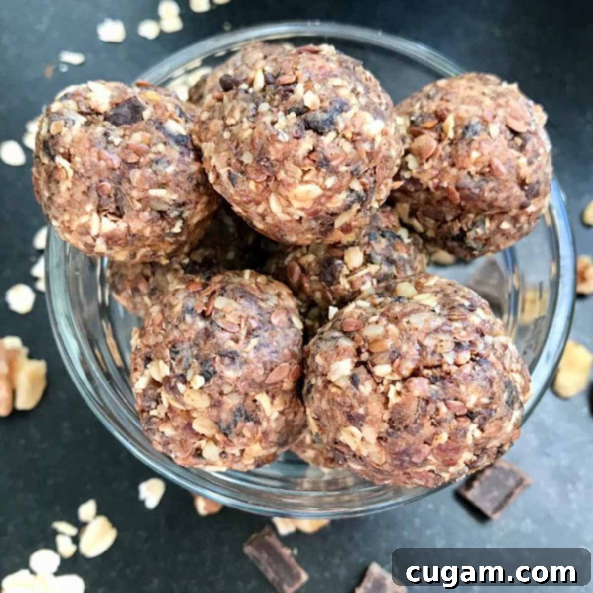 Close-up of a bowl filled with various no-bake energy balls, highlighting the visible oats, dates, chocolate chunks, and dried cherries.