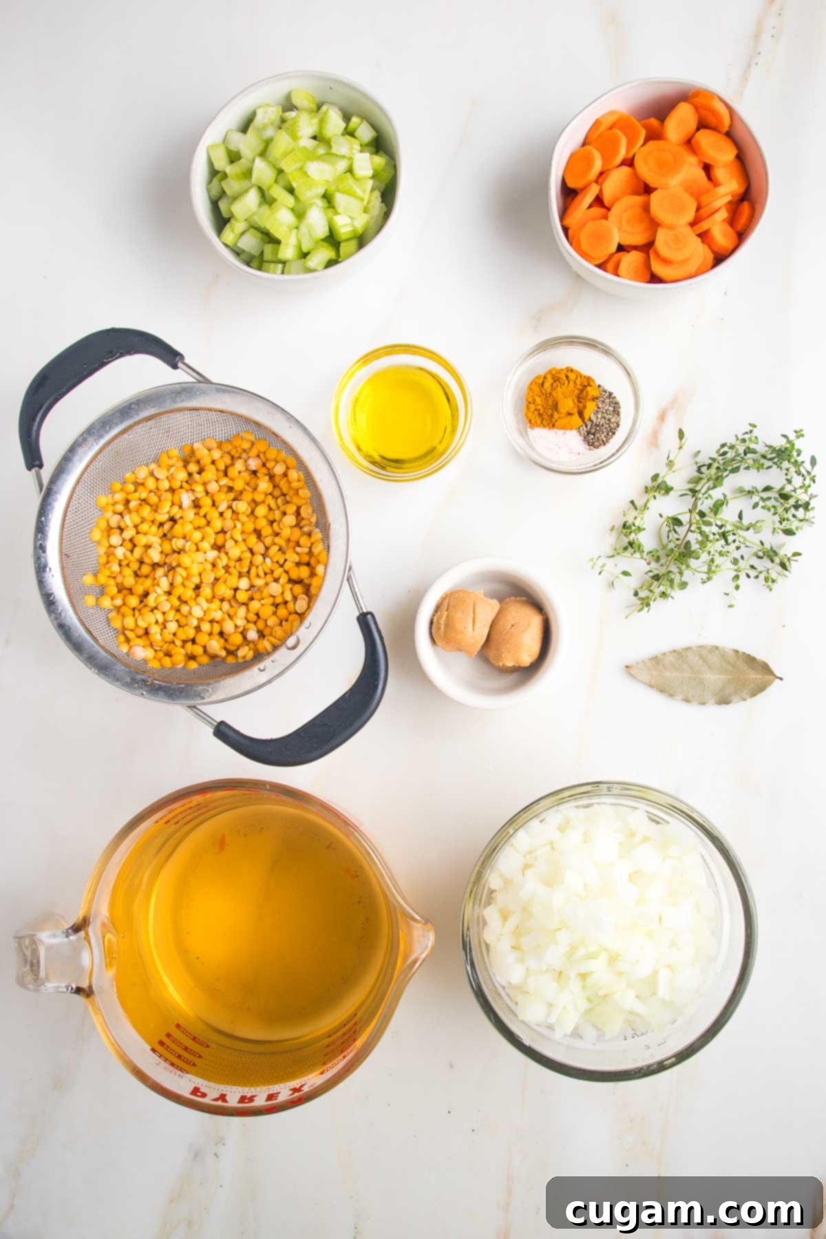 Small dishes with split pea soup ingredients: chopped celery, carrots and onions, rinsed yellow split peas, olive oil, spices, miso paste, fresh thyme, bay leaf and veggie stock. 