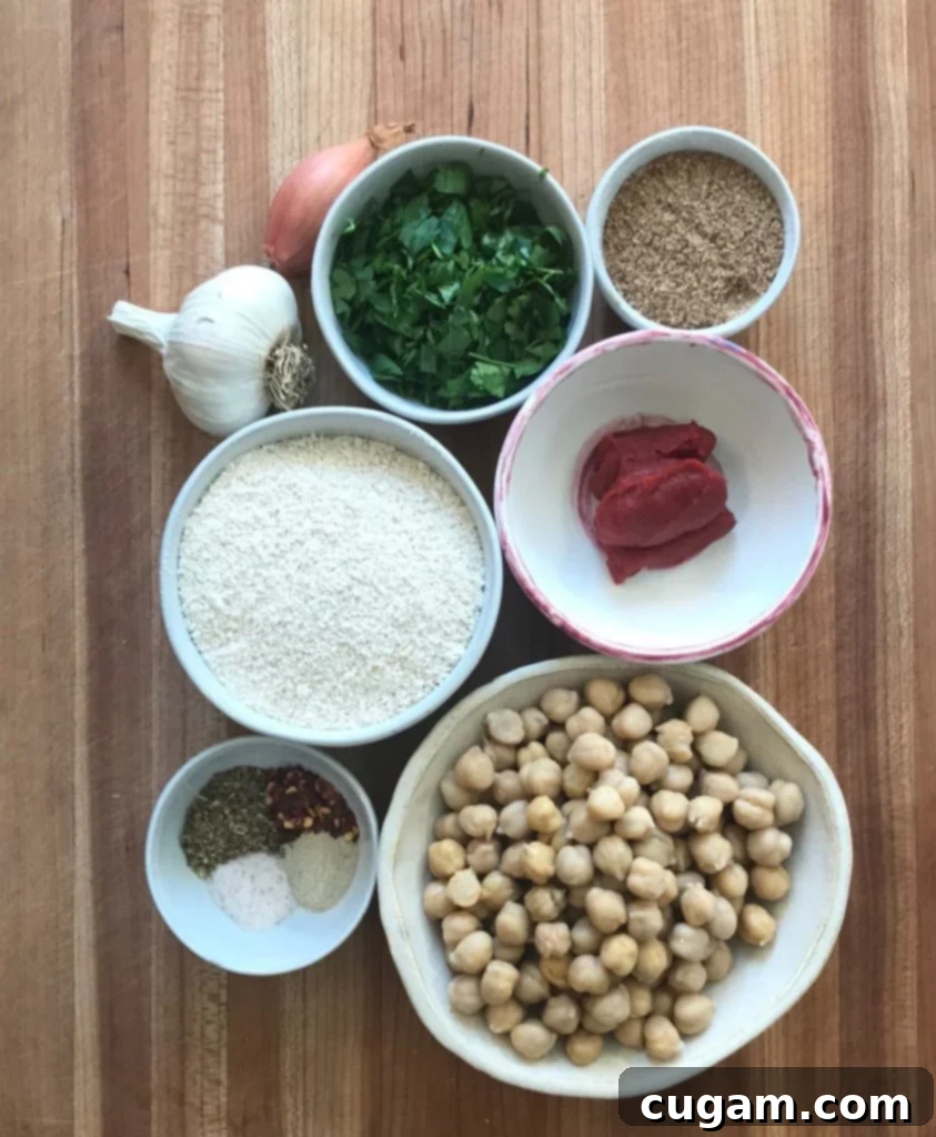 A selection of fresh ingredients for vegan meatballs: vibrant parsley, pungent garlic, delicate shallot, ground flaxseed, rolled oats, rich tomato paste, and wholesome chickpeas, all ready for preparation.