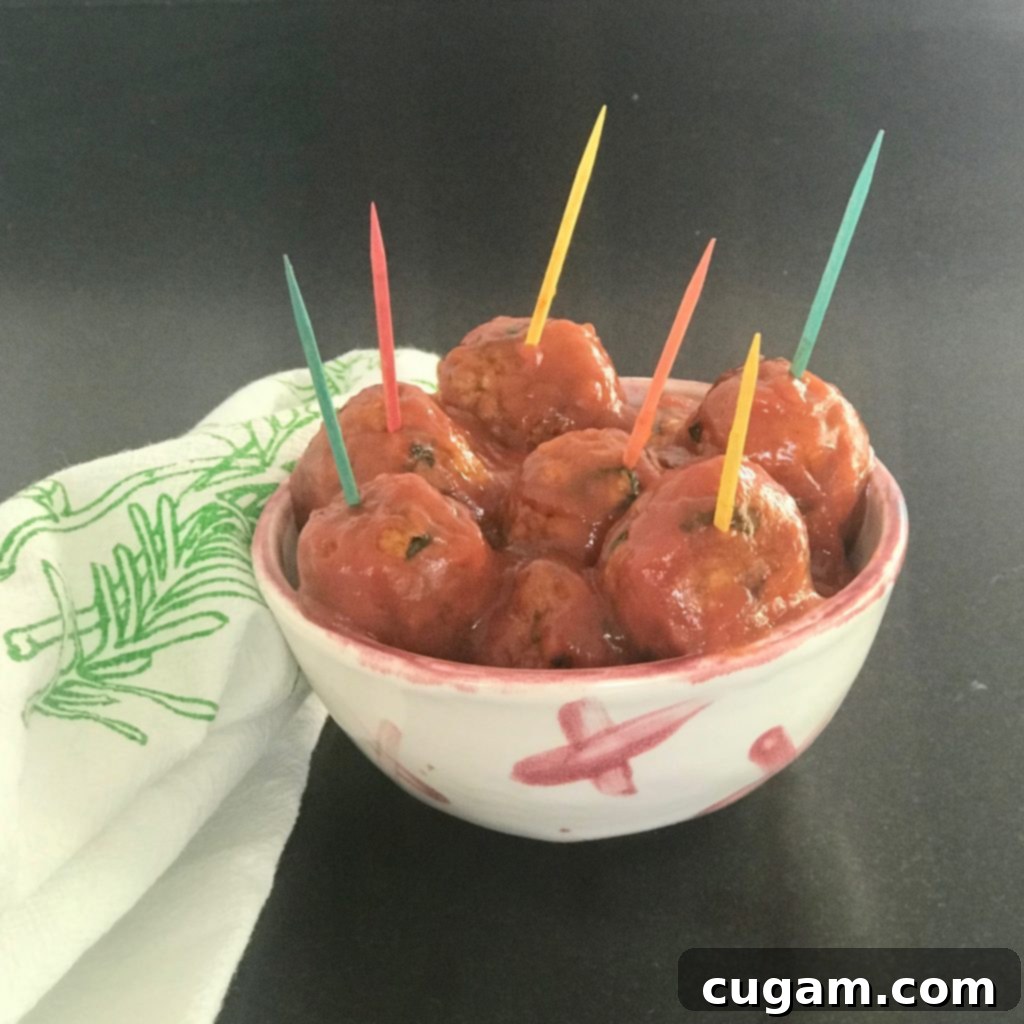 A small dish brimming with vegan sweet and sour meatballs, each adorned with a vibrant, colorful toothpick, ready for a festive occasion.
