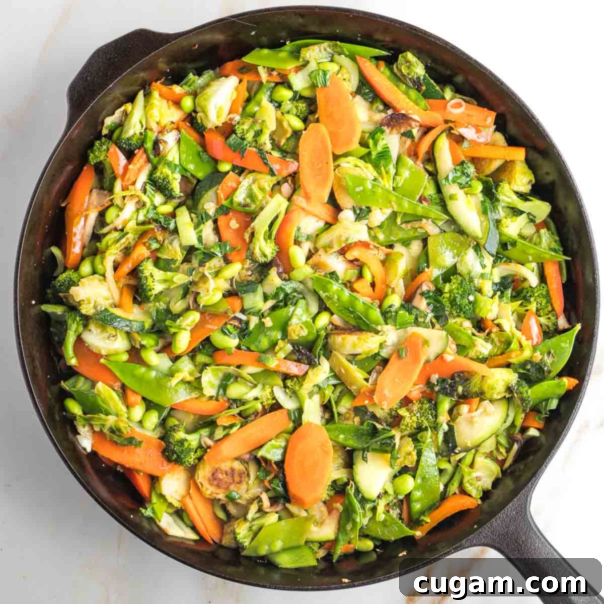 Stir-fried vegetables being mixed with garlic, ginger, and scallions until fragrant.