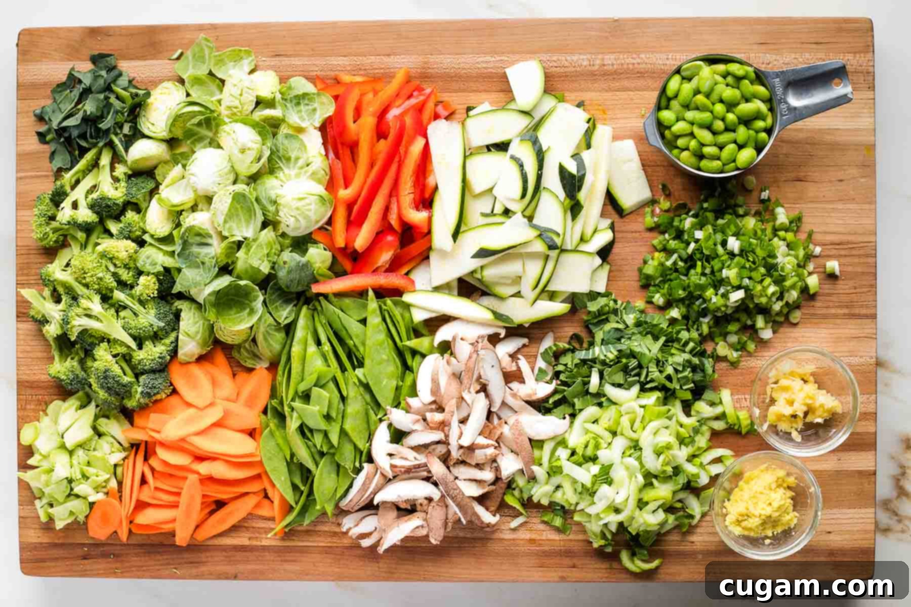 Colorful chopped veggies on a cutting board, organized by cooking time.