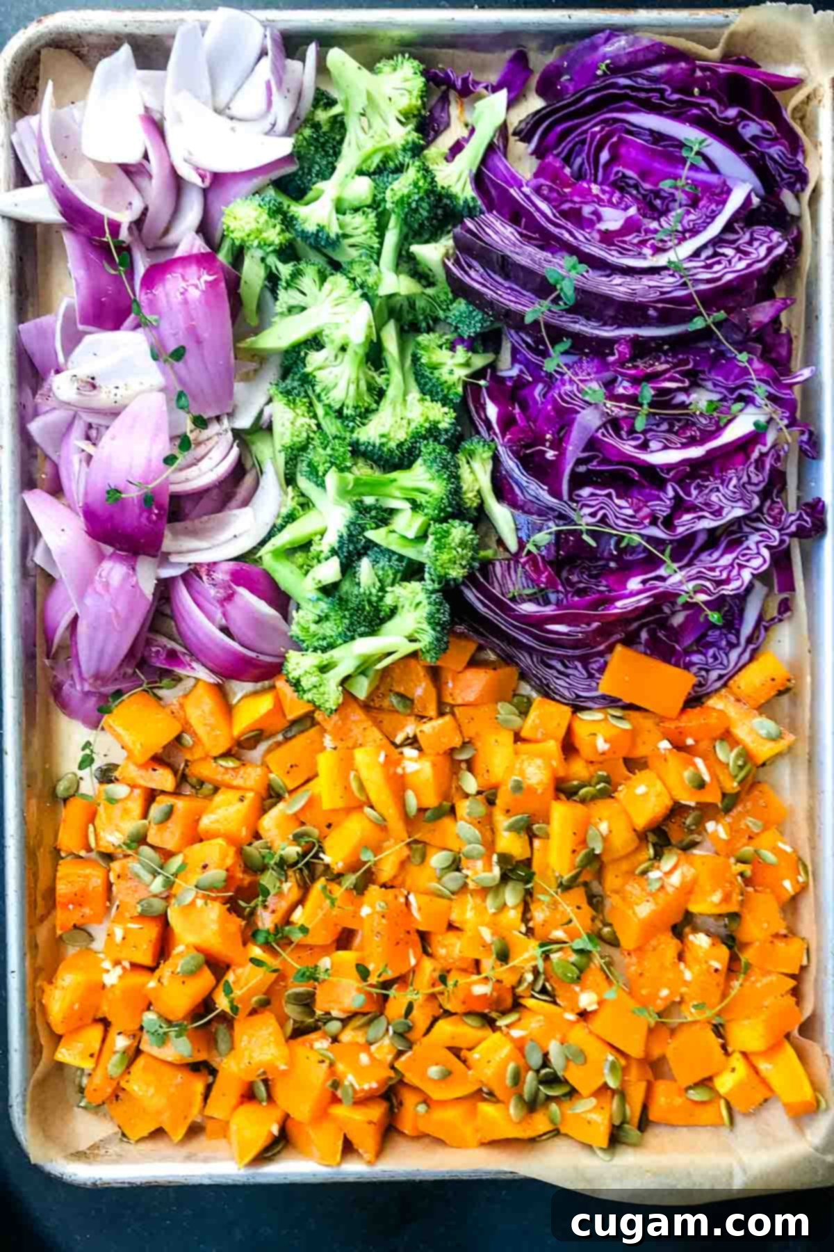 Large baking tray with sections of cabbage, butternut squash, broccoli and onions.