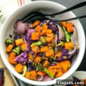 Bowl of roasted butternut with purple cabbage, onions, broccoli and fresh herbs.
