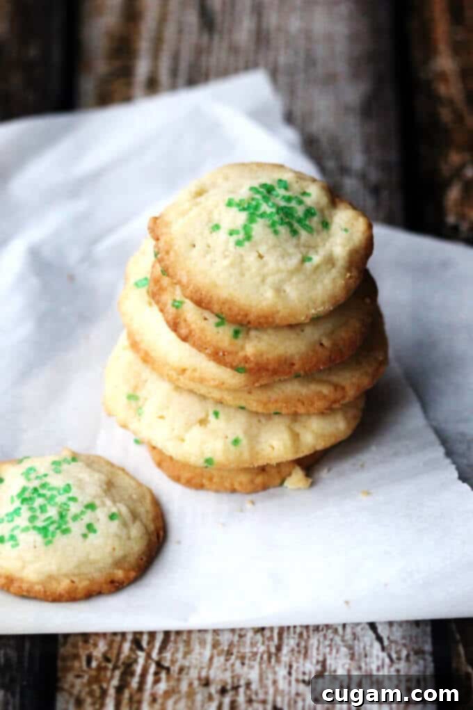 A child's hands carefully dropping dollops of 5-Ingredient Butter Vanilla Cookie dough onto a parchment-lined baking sheet, symbolizing the ease of this kid-friendly recipe.