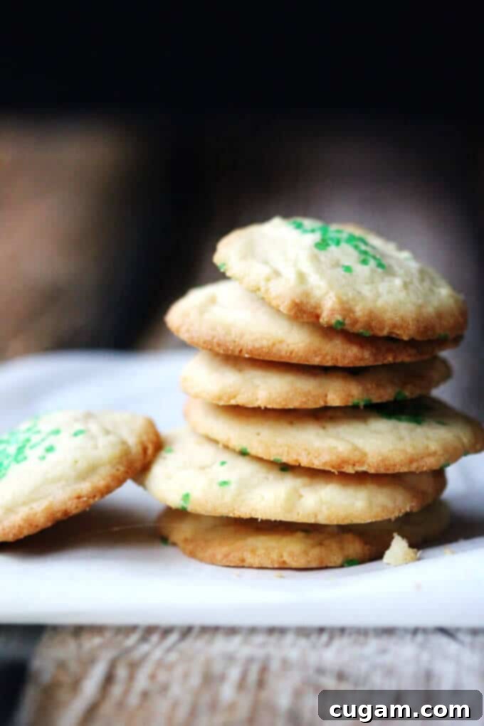 Close-up shot of a plate of 5-Ingredient Butter Vanilla Cookies, showing their golden texture and enticing simplicity, with a hint of green sprinkles.