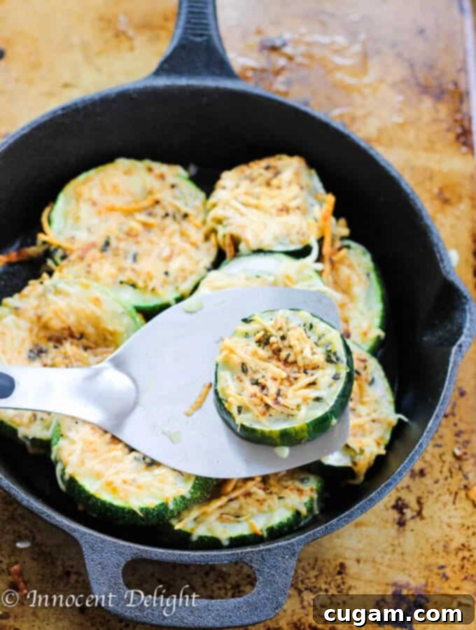 Close-up of golden brown parmesan crusted zucchini slices with herbs