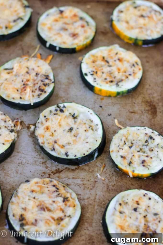 Serving of parmesan crusted zucchini on a plate with fresh lemon and thyme