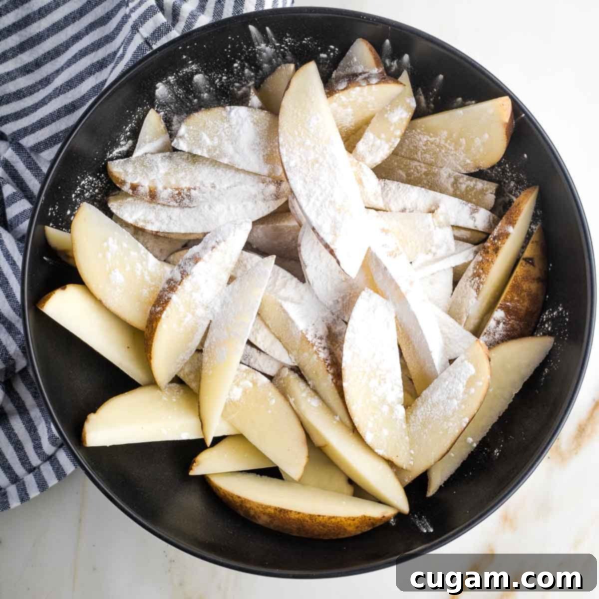 Bowl of potato wedges sprinkled with white powder.