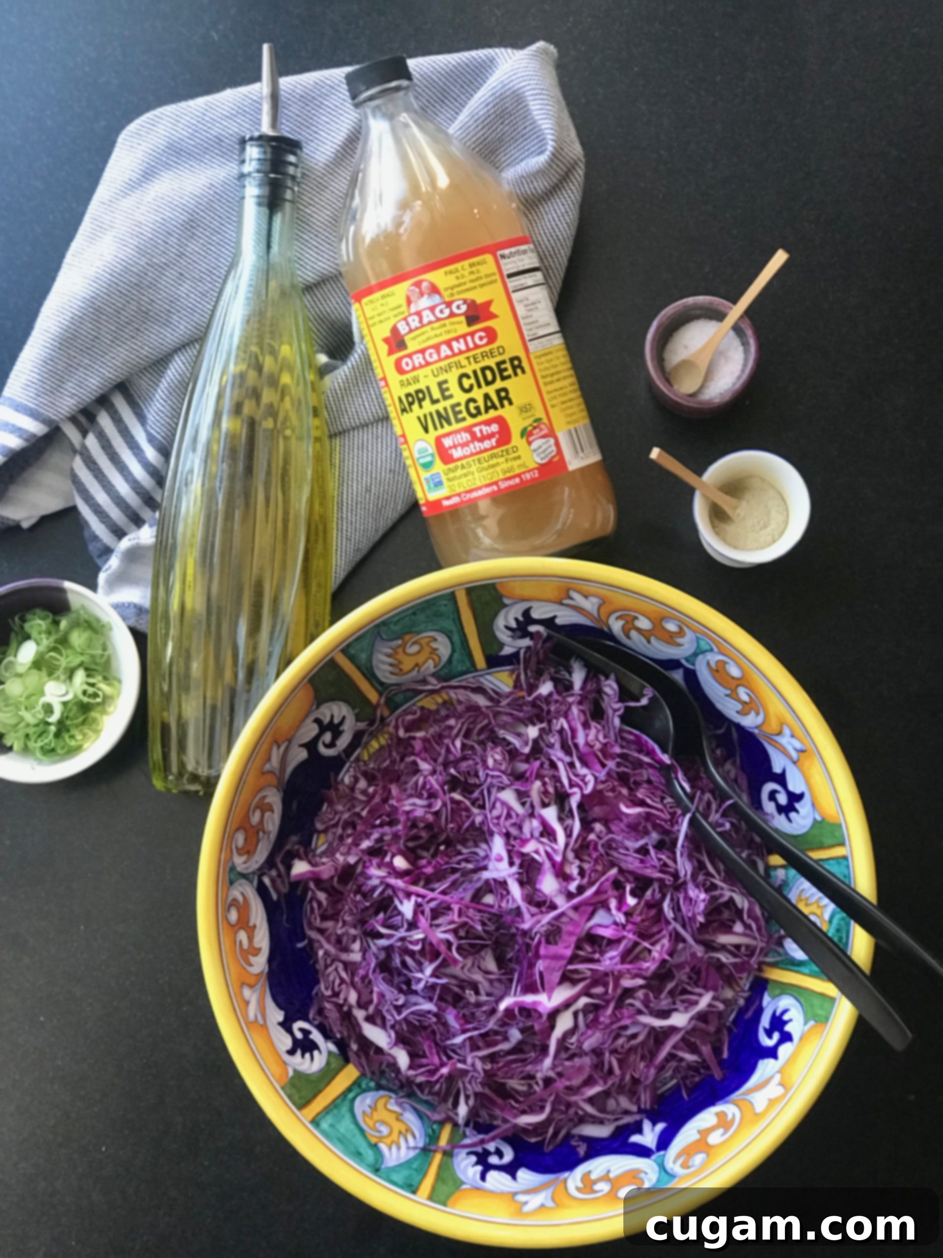 Bowl of thinly sliced cabbage plus olive oil, scallions and apple cider vinegar.
