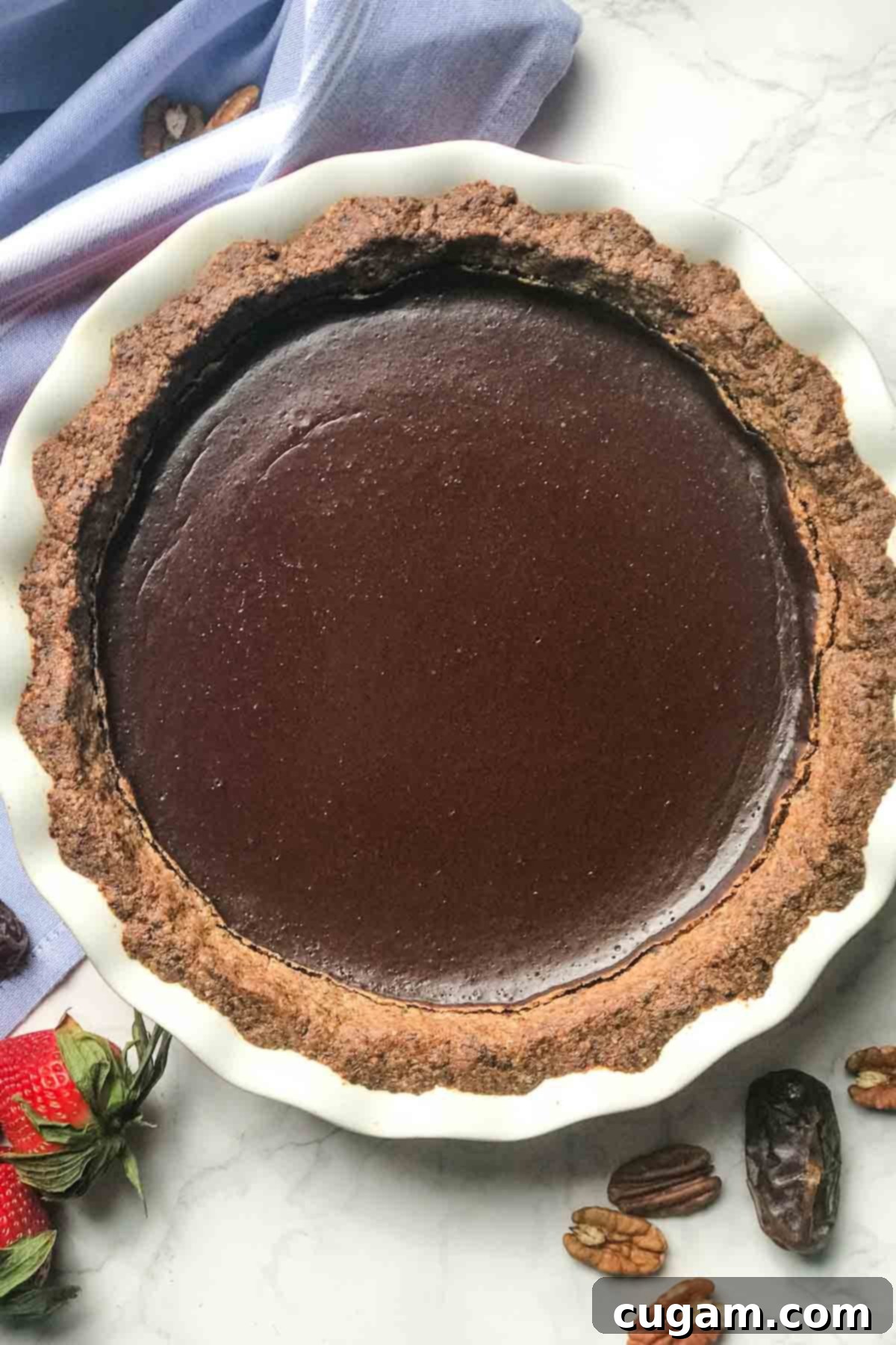 Chocolate pudding inside a nutty crust. Healthy chocolate pie surrounded by dates, pecans and strawberries.