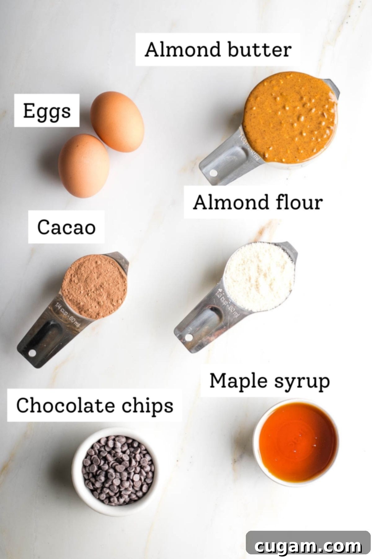 Clearly labeled ingredients for double chocolate chip cookies: eggs, almond butter, cacao powder, almond flour, chocolate chips, and maple syrup.