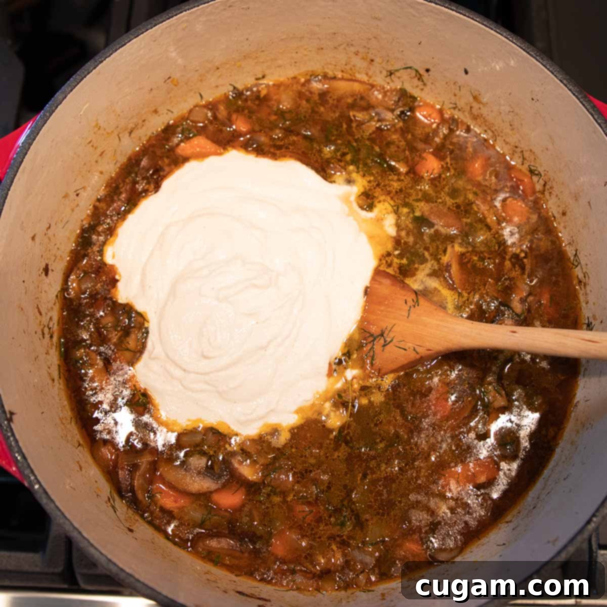 Cashew cream poured into a dutch oven with chunky mushroom soup.