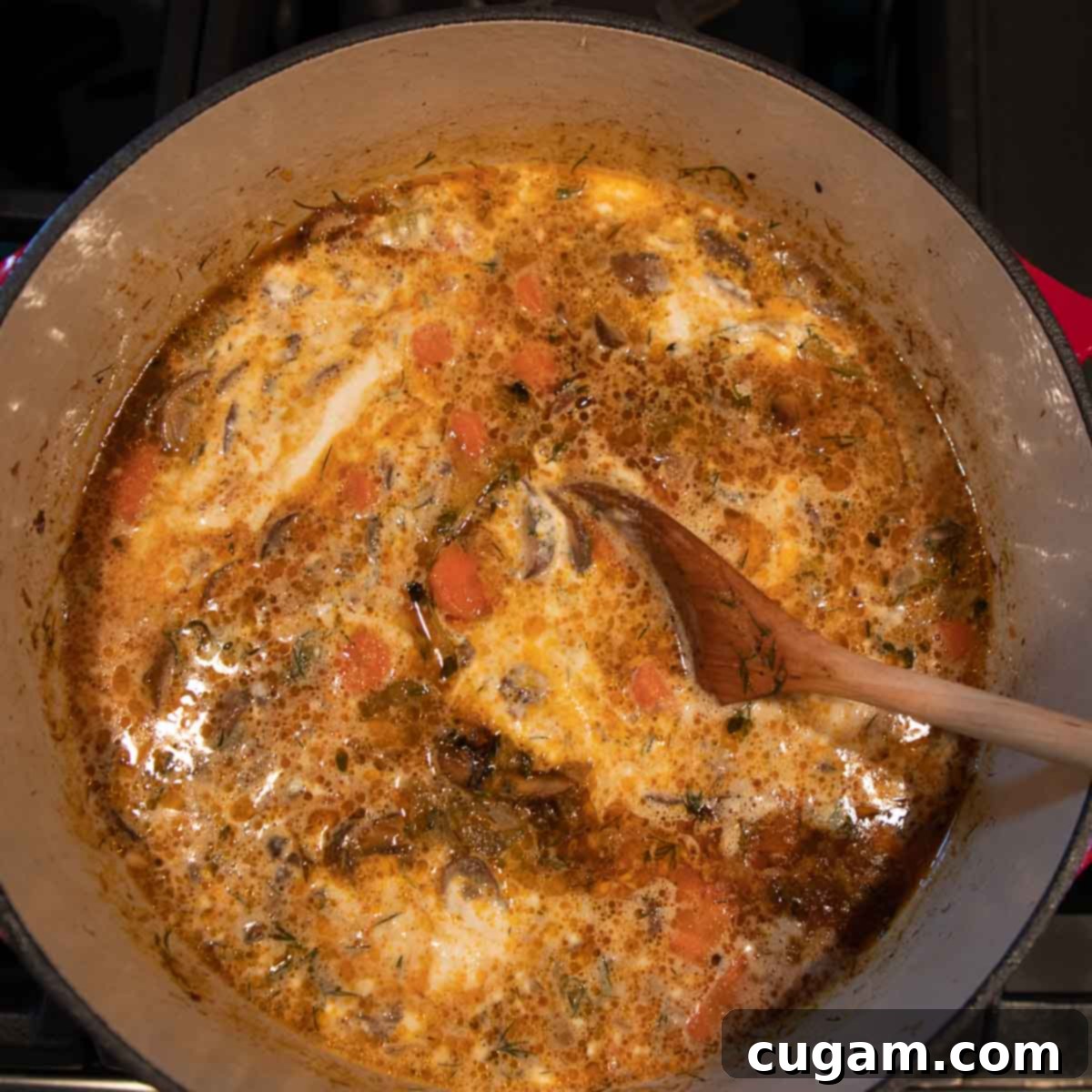 Mixing cream into mushroom soup.