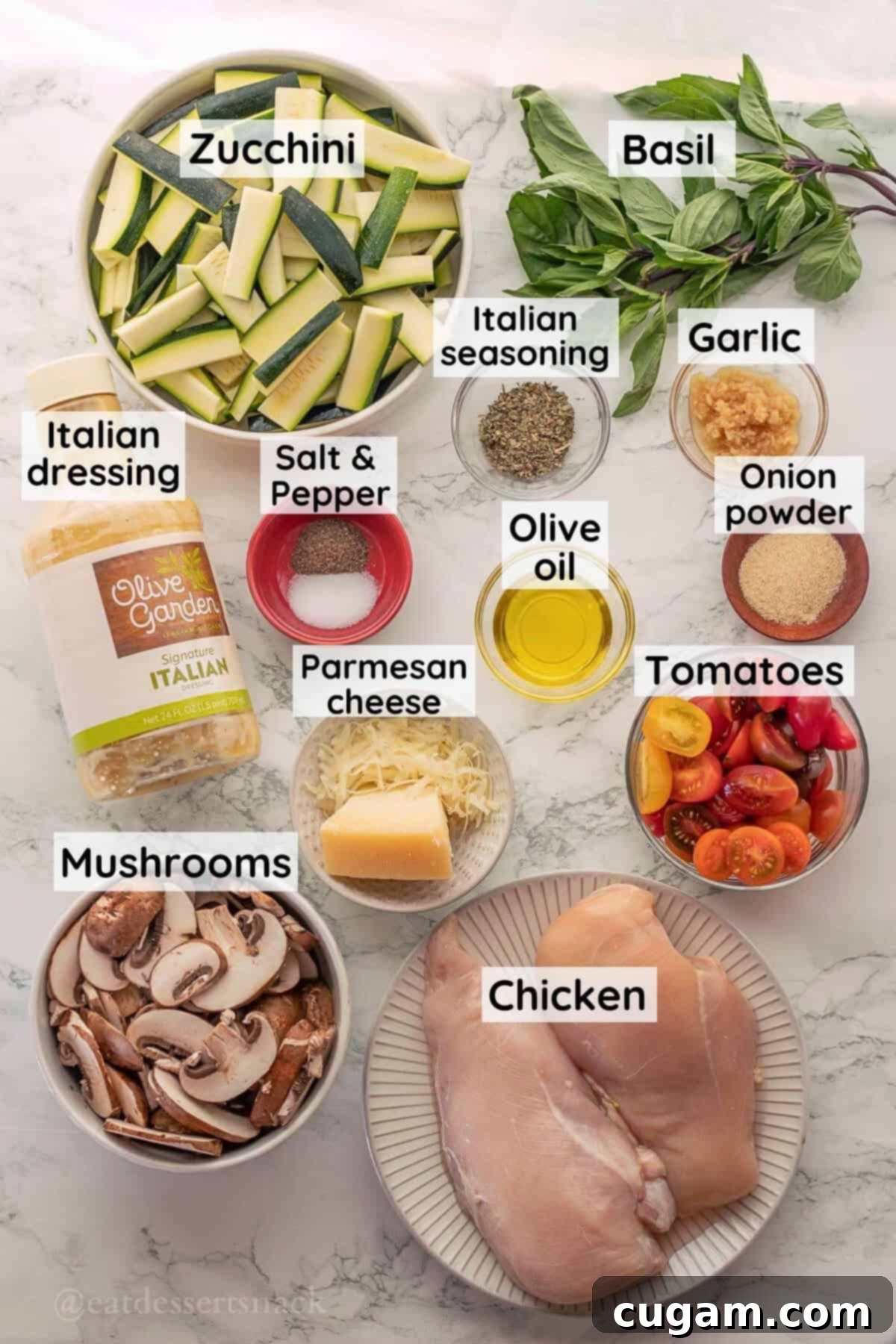 Savory Chicken Zucchini Tomato Skillet 3 Fresh ingredients laid out for Italian Chicken Zucchini Mushroom Skillet on a marble countertop, including diced chicken, sliced zucchini, mushrooms, grape tomatoes, Italian dressing, and Parmesan cheese.