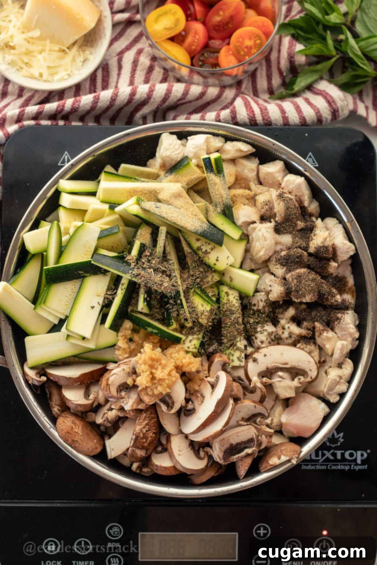 Savory Chicken Zucchini Tomato Skillet 5 Partially cooked chicken, raw sliced zucchini, mushrooms, and spices like Italian seasoning, garlic powder, onion powder, salt, and pepper in a metal pan, ready to be sautéed together.
