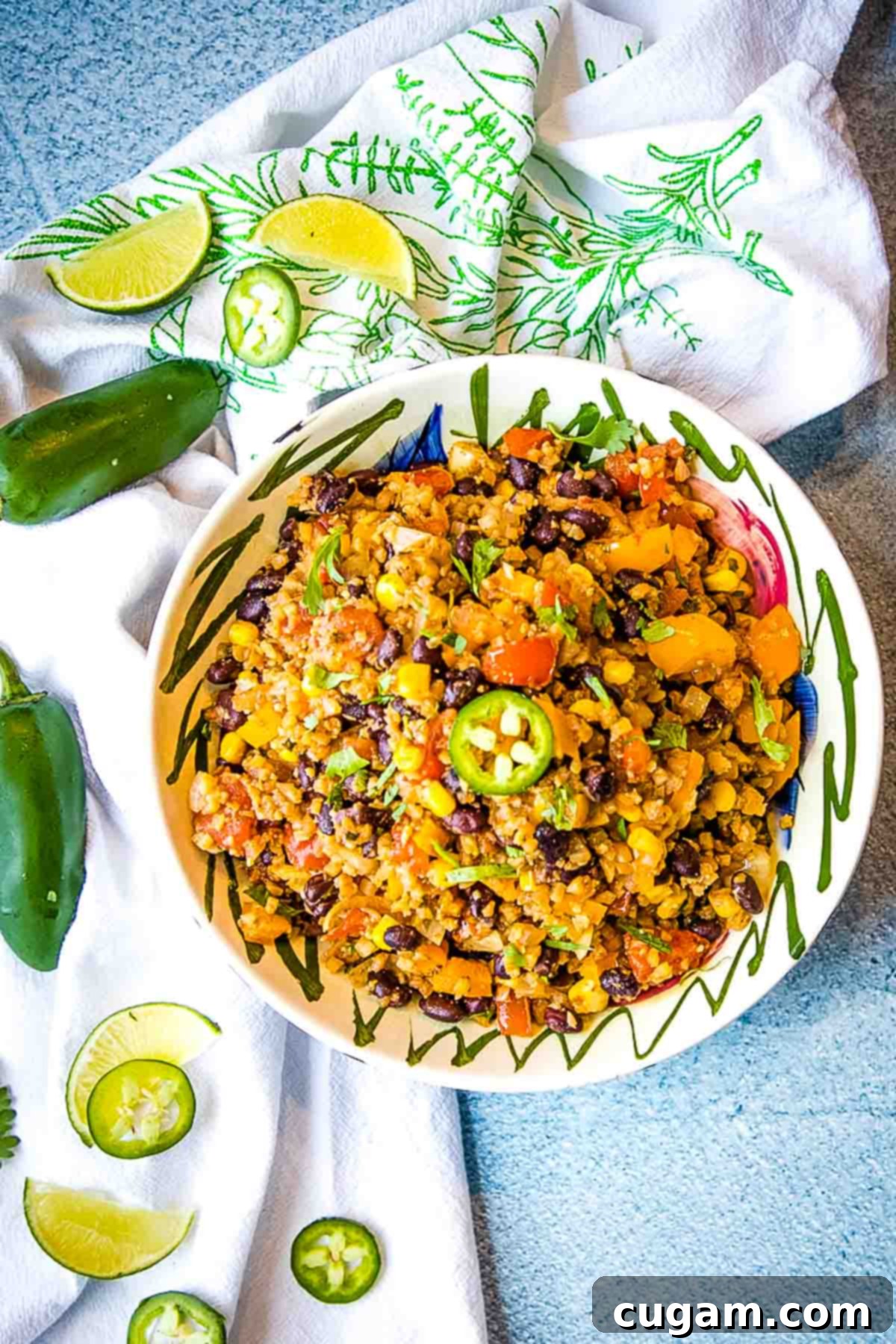 Mexican cauliflower rice with chunks of tomato, beans, corn and jalapeno slices.
