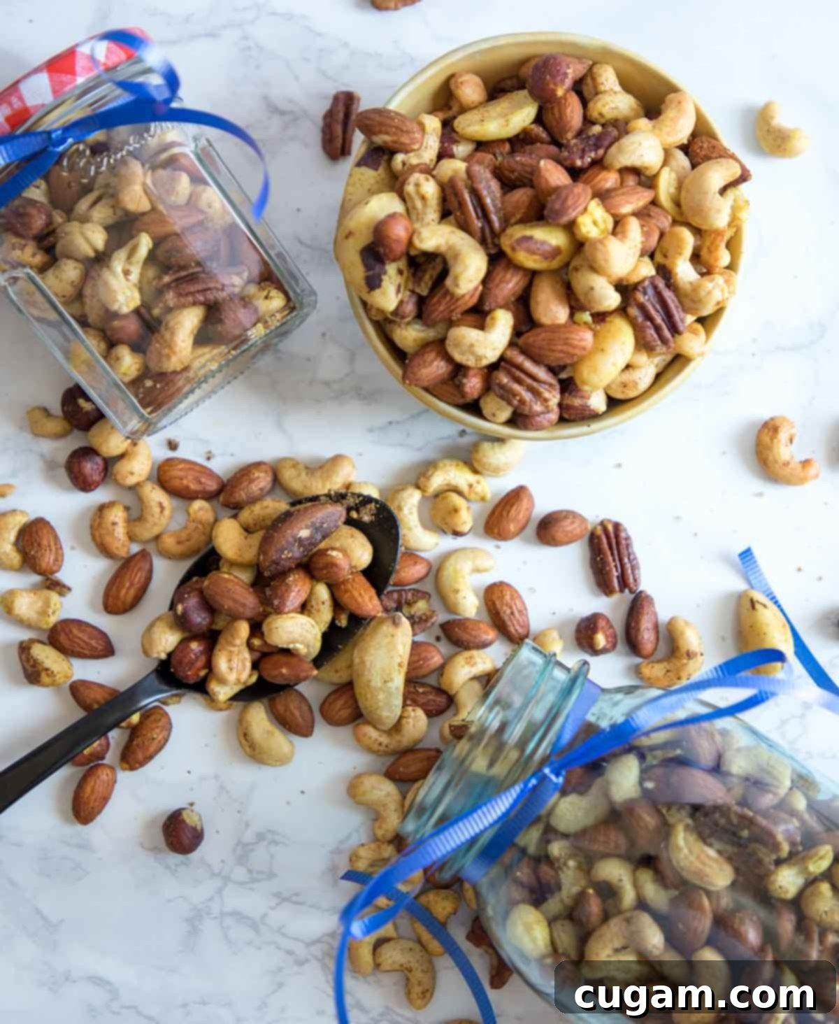 Assorted spiced nuts, elegantly spilling out of ribboned jars and artfully arranged in a bowl, showcasing their festive appeal.