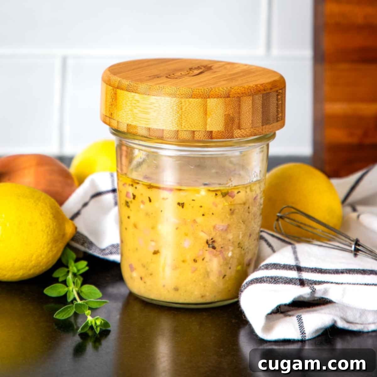 Two glass jars of homemade salad dressing, one open with a spoon, on a rustic wooden surface, highlighting meal prep convenience.