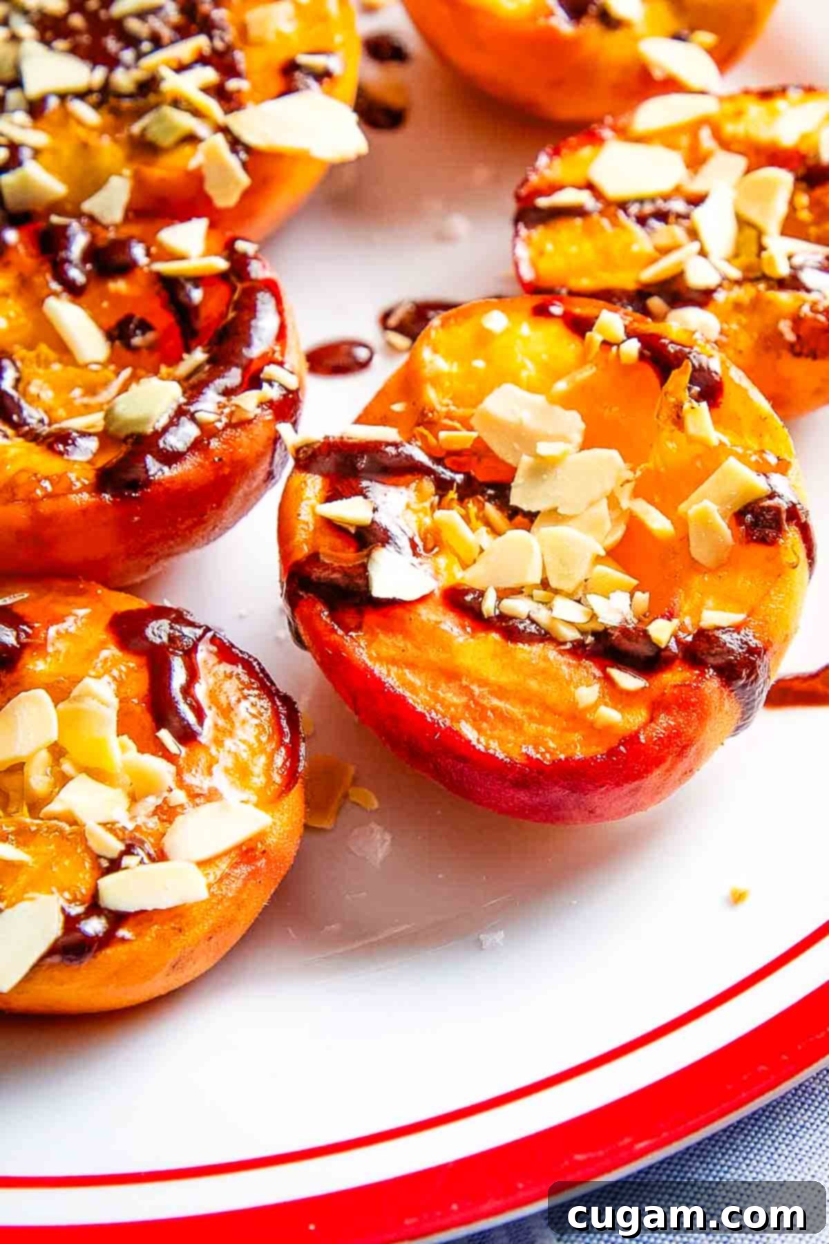 Grilled peach halves, drizzled with chocolate and sprinkled with nuts and salt, ready to serve.