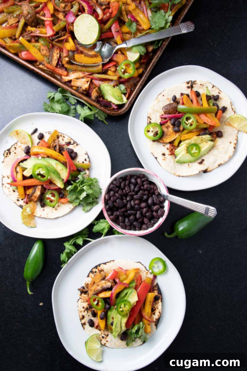 Roasted veggies on top of tortillas with bean and avocado