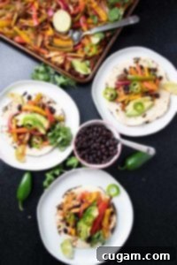Roasted veggies on top of tortillas with bean and avocado