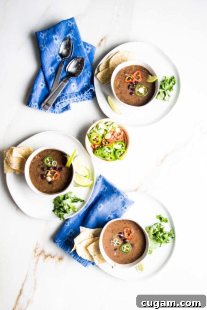 Simple Black Bean Bliss 13 Three colorful bowls of vegan black bean soup, each adorned with unique and fresh toppings, ready to be enjoyed.