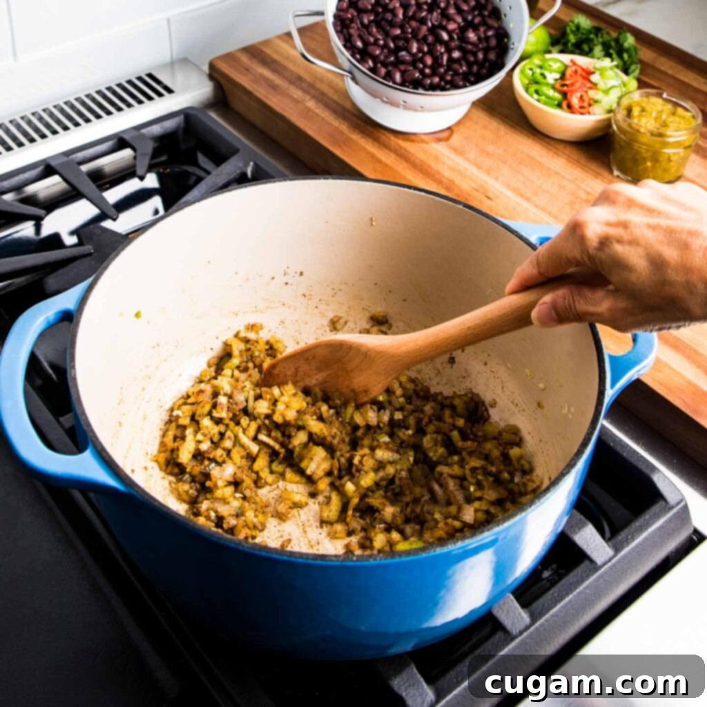 Simple Black Bean Bliss 7 Minced garlic and finely chopped jalapeño on a cutting board, prepared for sautéing to build the soup's aromatic foundation.