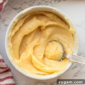White bowl of honey butter with spoon.