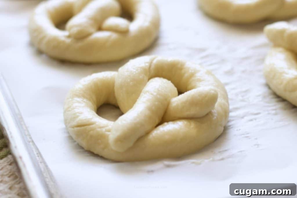 Raw Pretzels on parchment paper after boiling.