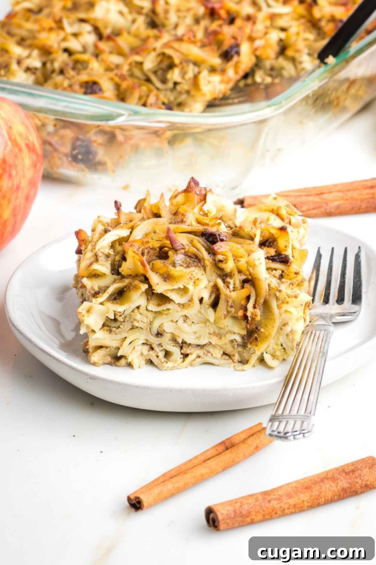 A close-up of a wooden spoon stirring the raw kugel mixture in a large bowl, emphasizing the hands-on process and attention to detail in preparation.