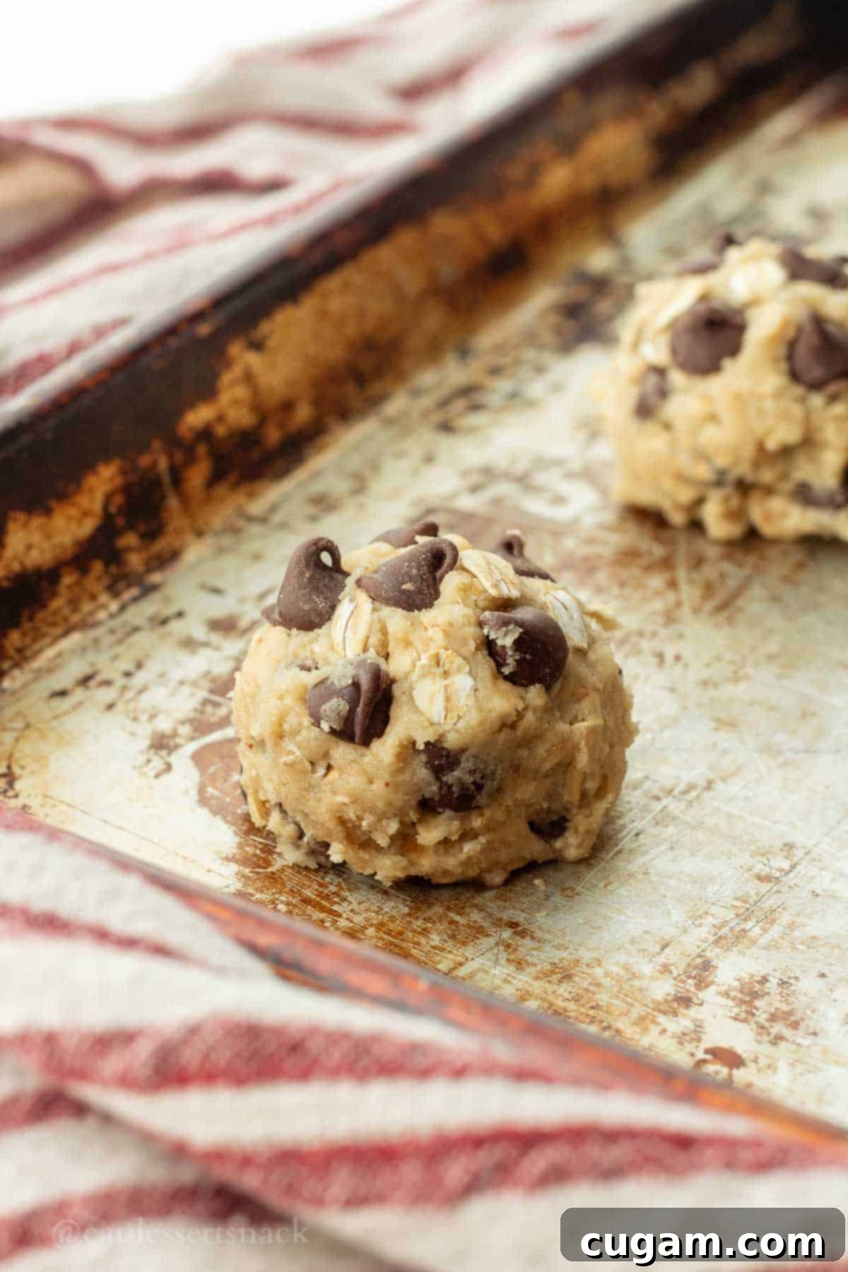 Sourdough Oatmeal Cookies 9 Raw cookie dough balls scooped onto a metal baking sheet, ready for the oven.