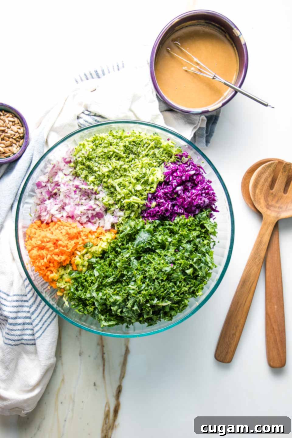 The Ultimate Chopped Salad 4 A large bowl filled with colorful, finely chopped vegetables next to a small bowl of whisked salad dressing.