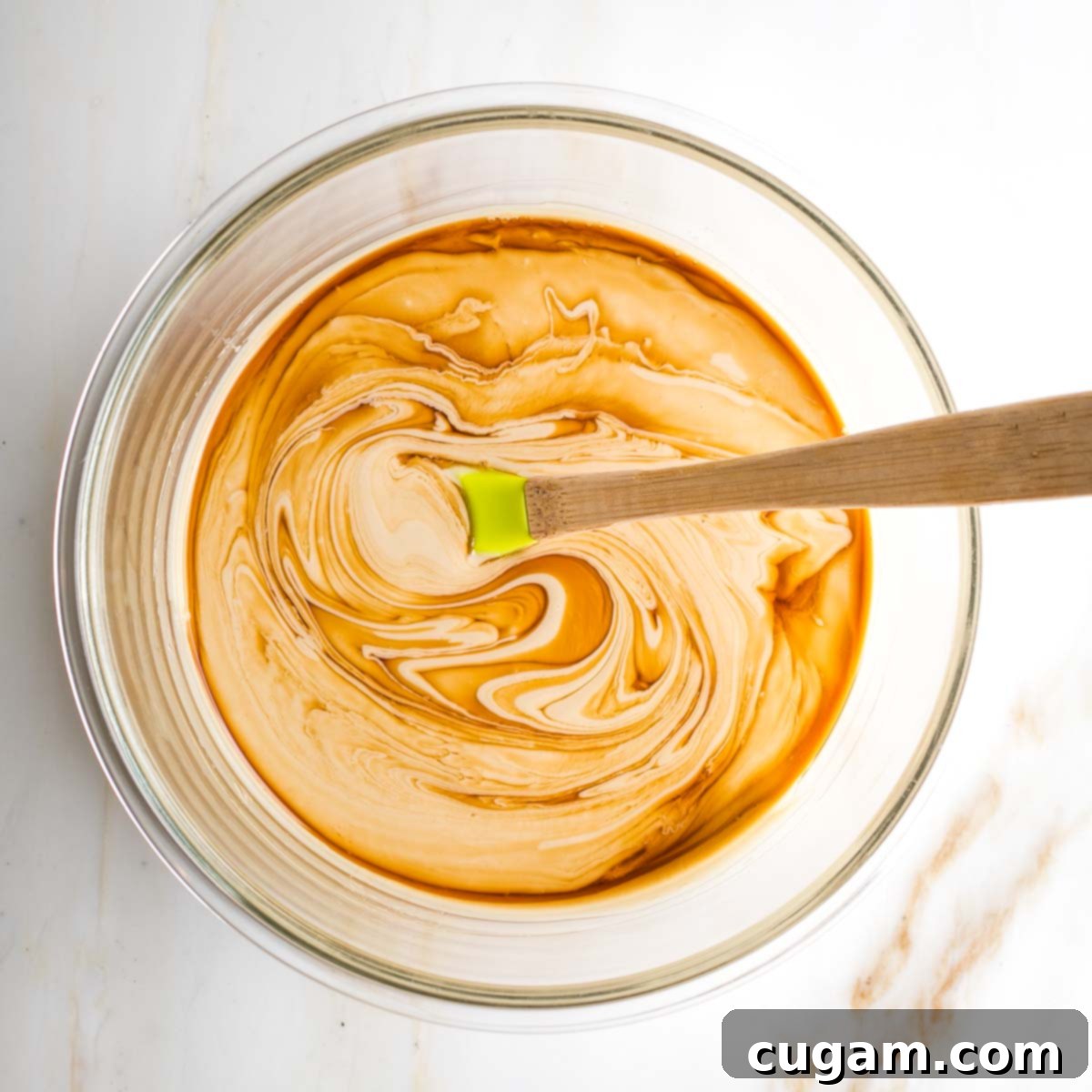 Wet ingredients for tahini brownies: tahini, maple syrup, and vanilla extract in a mixing bowl.