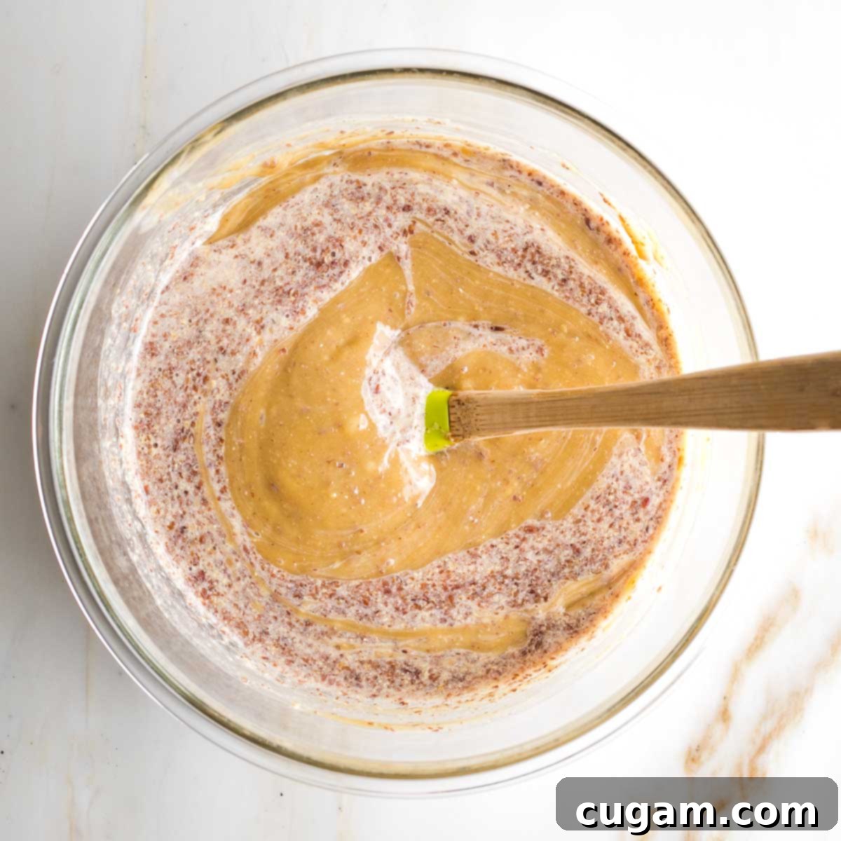 Wet ingredients for tahini brownies, including flax eggs, being mixed together to combine.