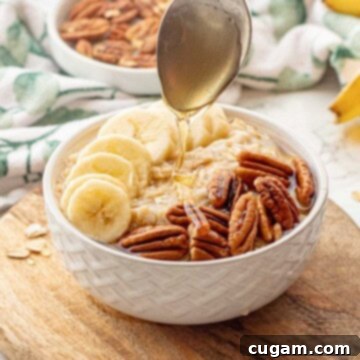 Banana Nut Oatmeal Bliss 10 Spoon drizzling honey over white bowl of banana oatmeal.