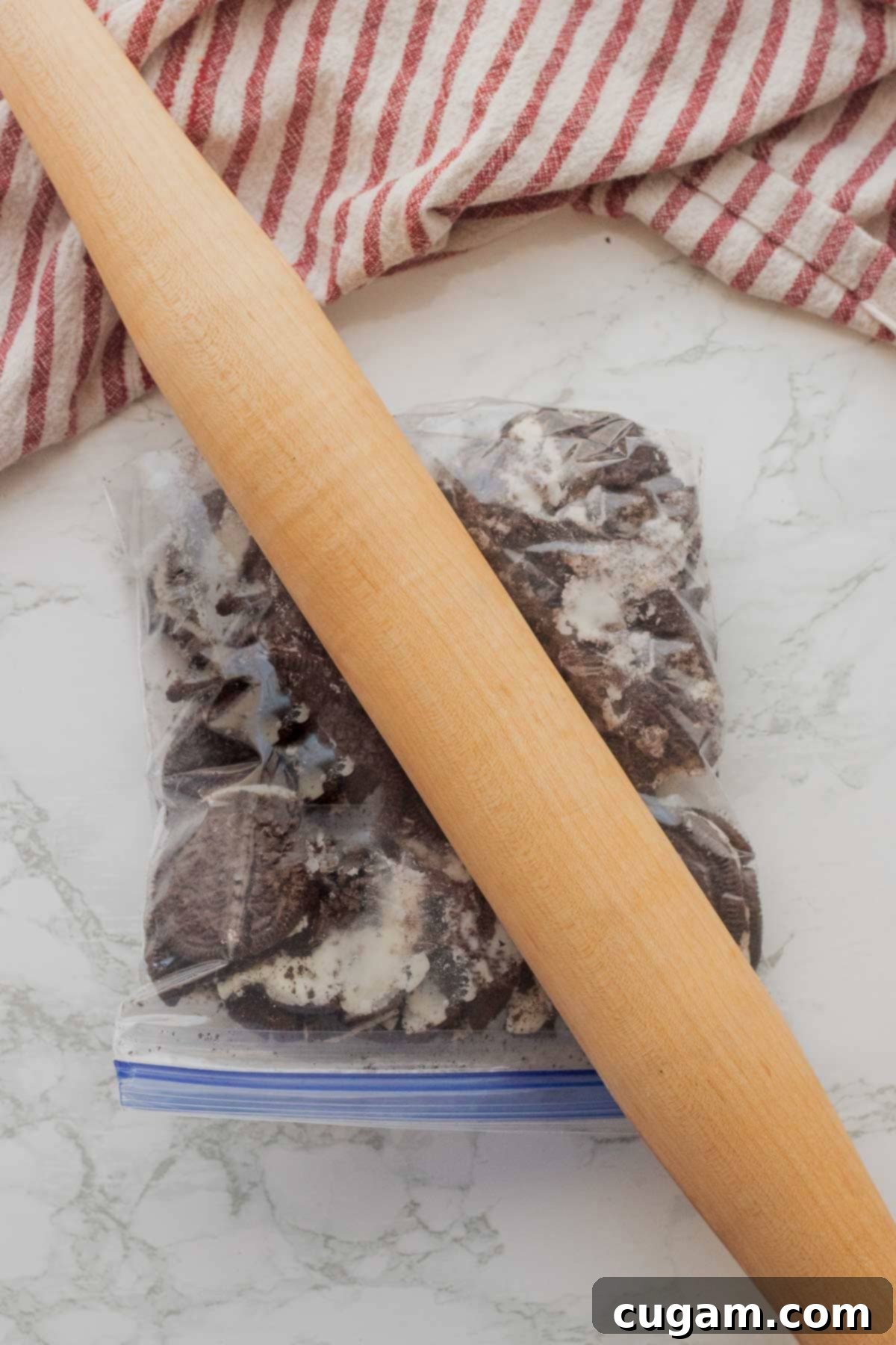 Rolling pin crushing a bag of Oreos to make cookie crumbs.