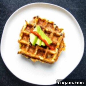 A cooked mashed potato waffle with toppings on a plate.