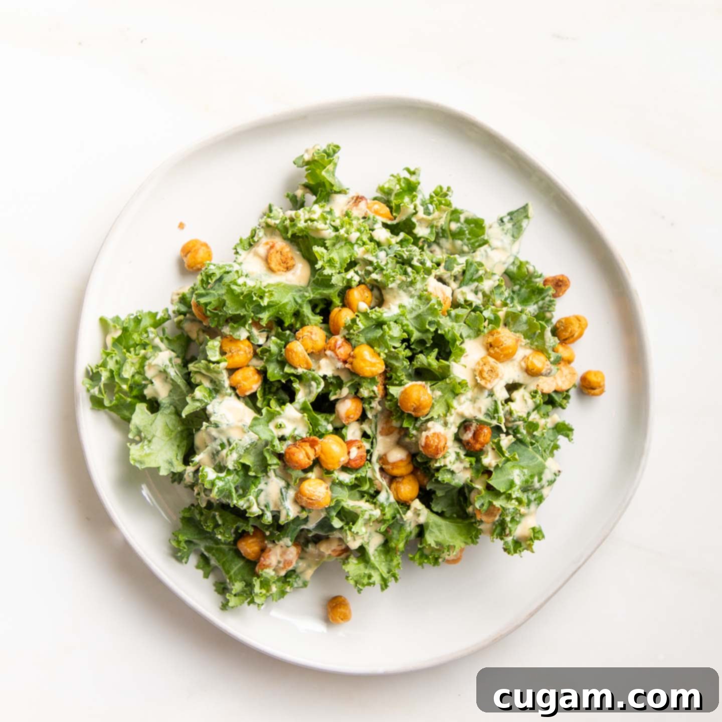 A plate with kale, creamy dressing and roasted chick peas. 