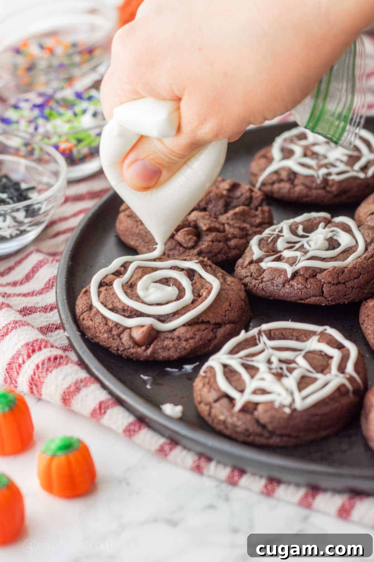 Spooky Spider Web Cookies 10 Melted white chocolate piped in a spiral pattern on a baked chocolate cookie, forming the base of the spider web.