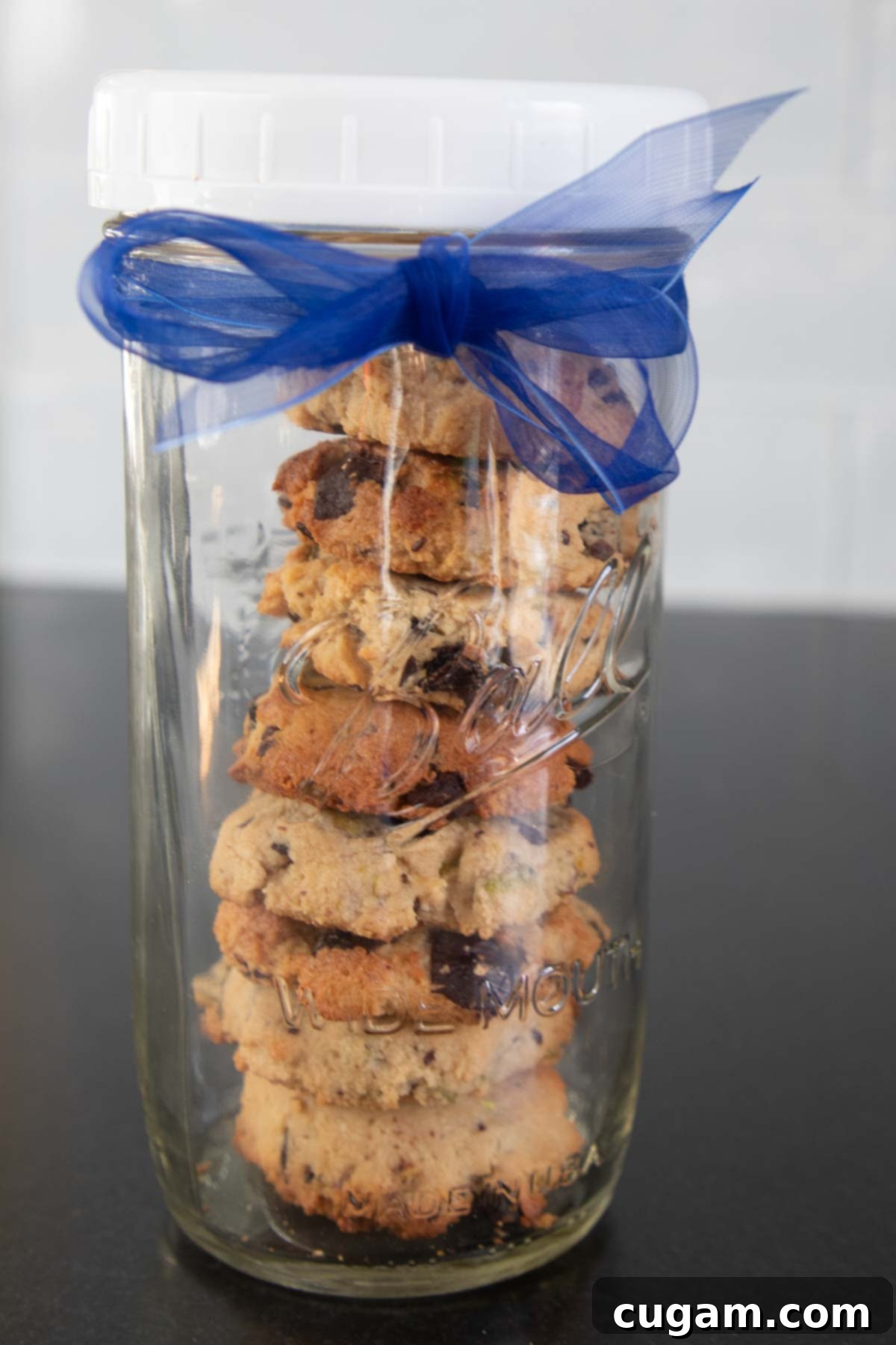 Chewy Vegan Gluten Free Chocolate Chunk Cookies 13 Stack of chocolate chunk cookies beautifully arranged in a tall jar with a blue ribbon, ready for gifting or storage.