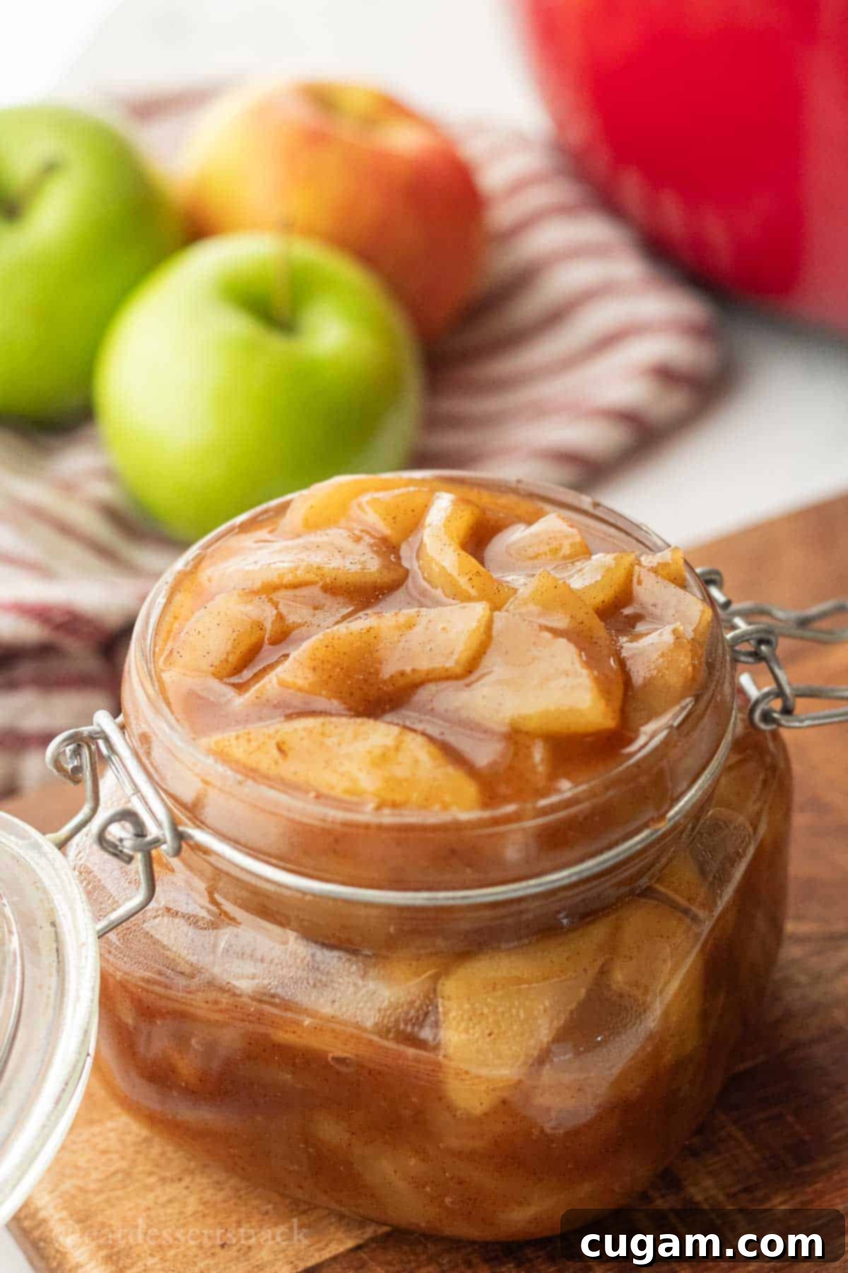 Cooked apple pie filling in glass jar.