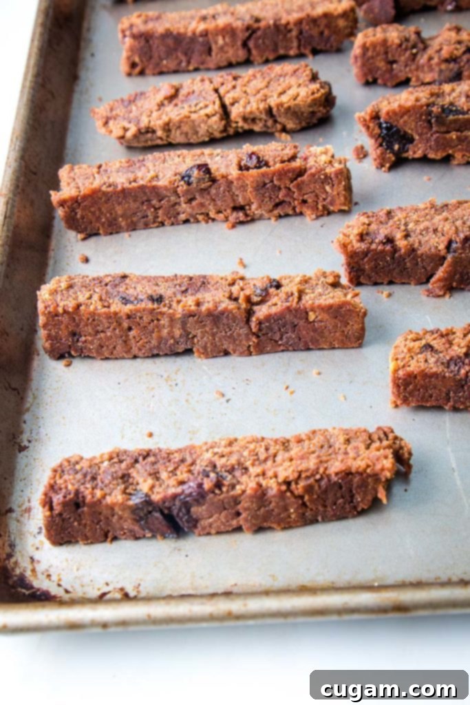 Thick, evenly sliced vegan gluten-free biscotti arranged on a baking tray, perfectly prepared for their second bake.