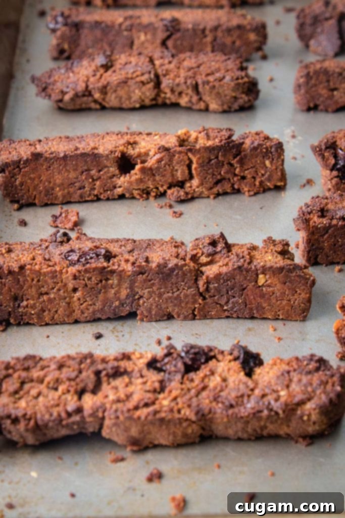 A baking tray filled with perfectly twice-baked vegan gluten-free biscotti, dried out and golden, ready to be enjoyed with a hot beverage.