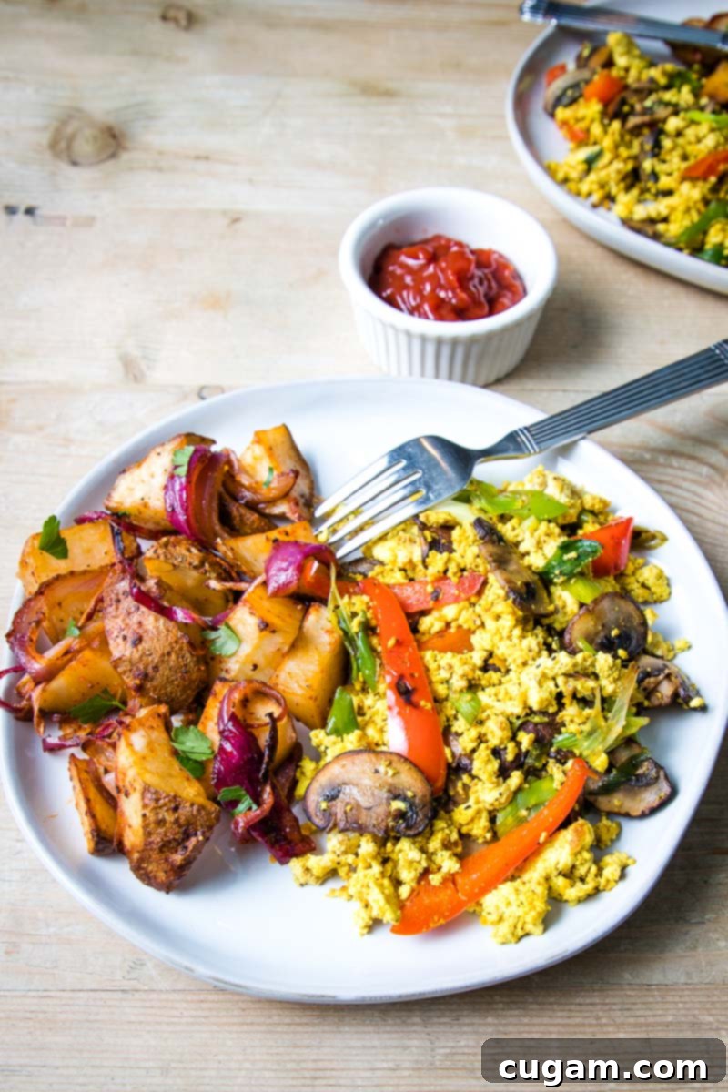large white plate with home fries and veggie scramble. 