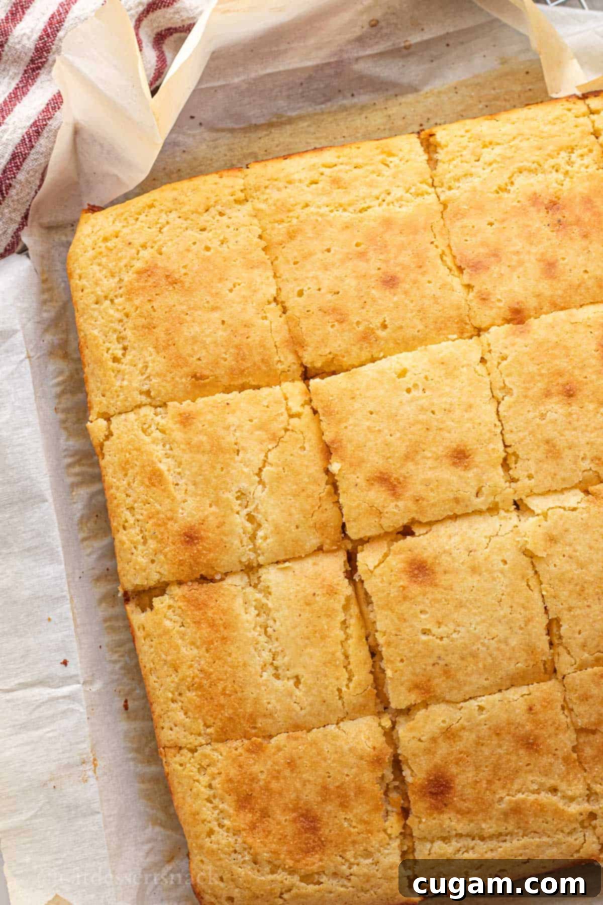 Baked and sliced cornbread on parchment paper.