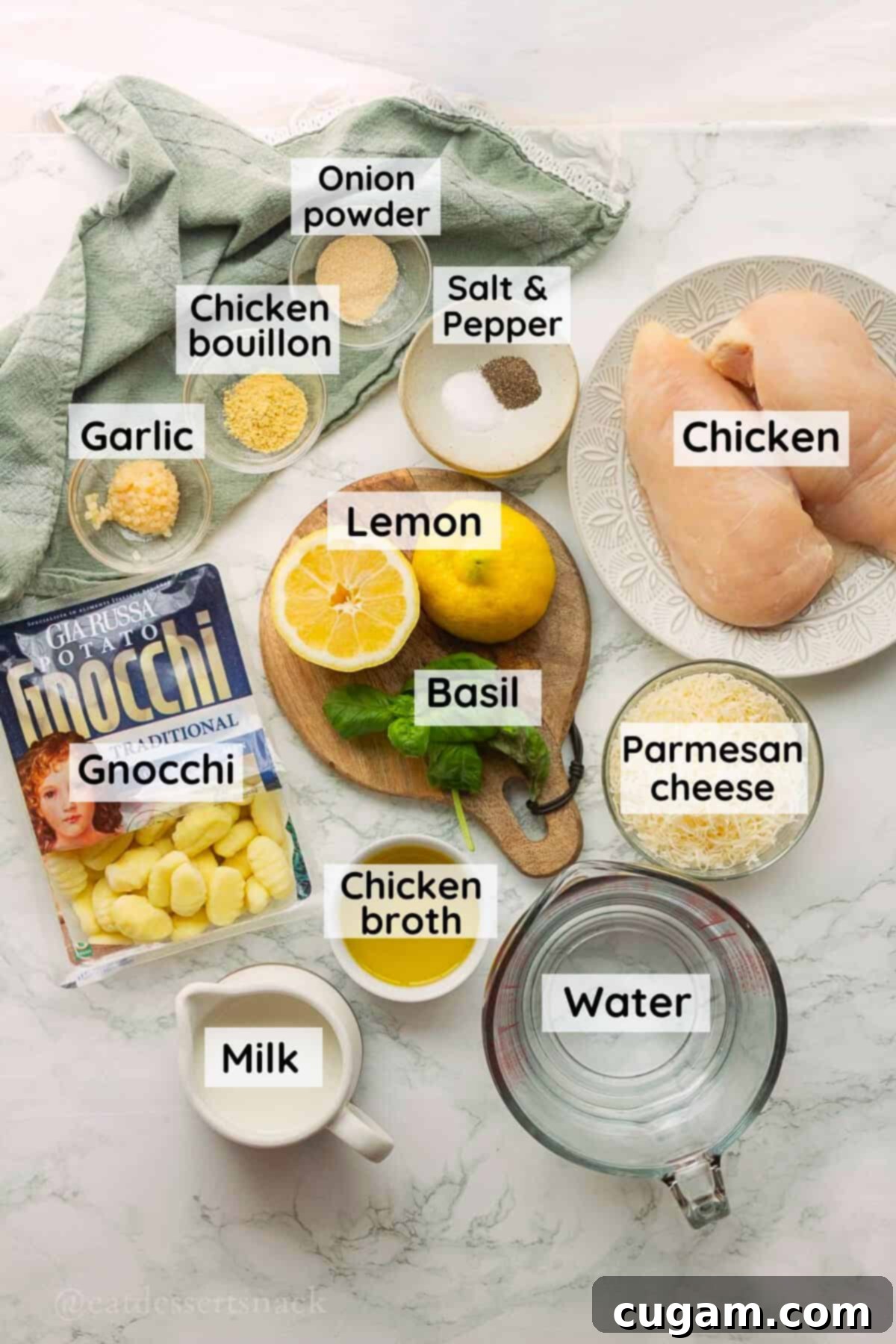 Labeled ingredients for lemon chicken gnocchi in glass bowls on marble countertop.